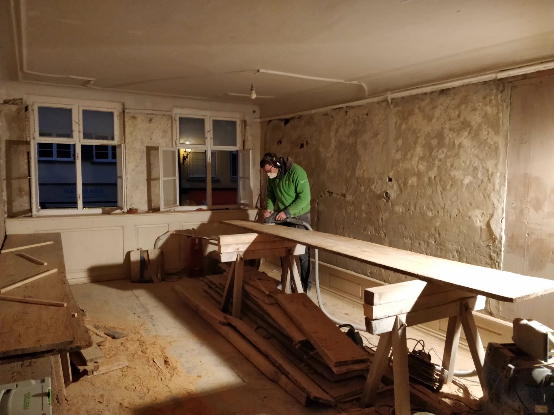Bauphase: Mitarbeiter bei Schleifarbeiten im Rohbau